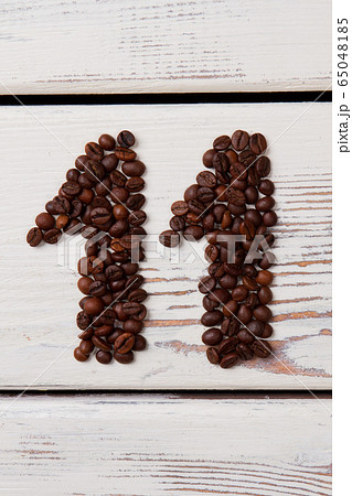 Brown coffee beans arranged in a shape of eleven. Brown coffee beans arranged in a shape of eleven. 65048185