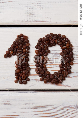 Brown coffee beans arranged in a shape of number ten. 65048186