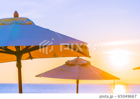 Beautiful tropical nature umbrella chair with palm tree around beach sea ocean at sunset or sunrise Beautiful tropical nature umbrella chair with palm tree around beach sea ocean at sunset or sunrise 65049667