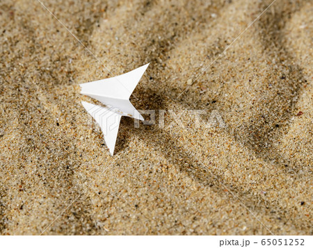 White paper plane on a yellow wavy sand. Metaphor air accident. Top view. White paper plane on a yellow wavy sand. Metaphor air accident. Top view. 65051252