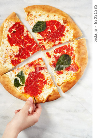 Hand grabbing pizza slice Hand grabbing pizza slice 65051585