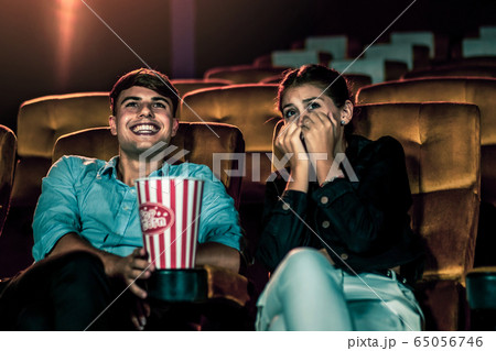 A couple of caucasian watch a movie in the cinema A couple of caucasian watch a movie in the cinema 65056746