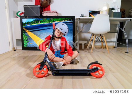 Boy imitating outdoor activities with kick scooter Boy imitating outdoor activities with kick scooter 65057198