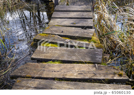 Old rickety rustic wooden jetty on a lake 65060130