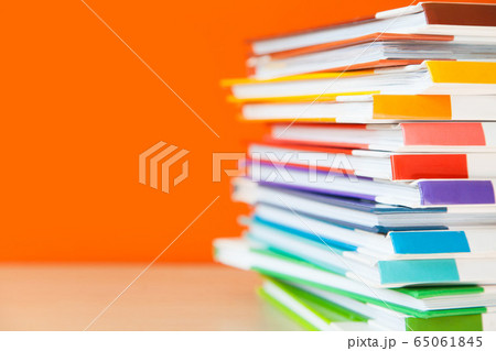 Stack of colorful books on color background. 65061845