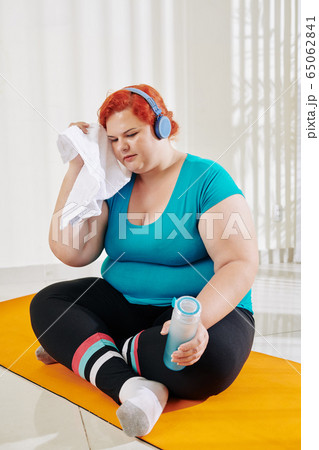 Sweaty woman after exercising at home Sweaty woman after exercising at home 65062841
