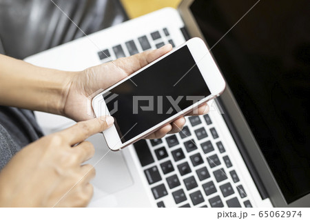 Working woman is working with a smart phone and 65062974