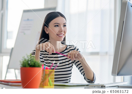 Dark-haired pretty woman in a striped shirt looking happy Dark-haired pretty woman in a striped shirt looking happy 65063172