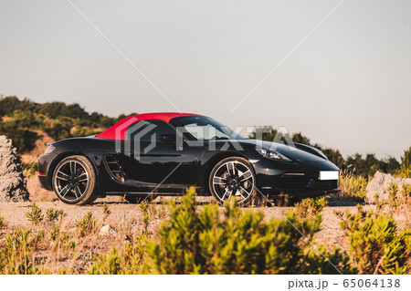 Black sport cabrilet with red roof parking on the nature Black sport cabrilet with red roof parking on the nature 65064138