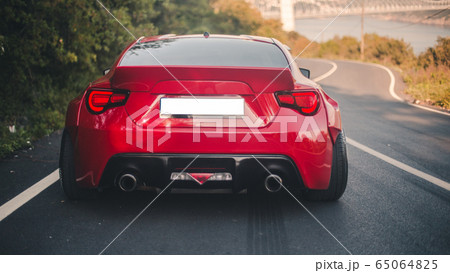 Modern red racing car commercial with panoramic view on the hill Modern red racing car commercial with panoramic view on the hill 65064825