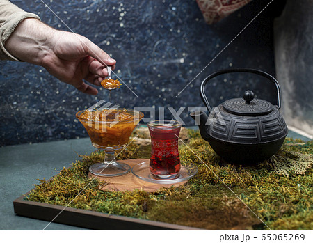 tea, teapot and tasty jam on green background tea, teapot and tasty jam on green background 65065269