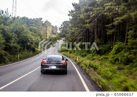 Grey color supercar motion in the rain forests Grey color supercar motion in the rain forests 65066637
