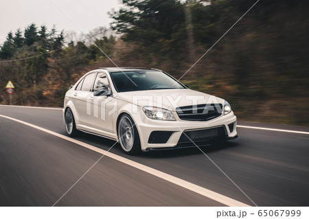 White sport sedan on the highway. High speed drive. Front view 65067999