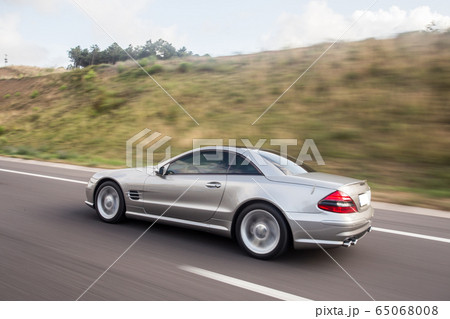 Silver chasing car on the mountain road, across farmlands Silver chasing car on the mountain road, across farmlands 65068008
