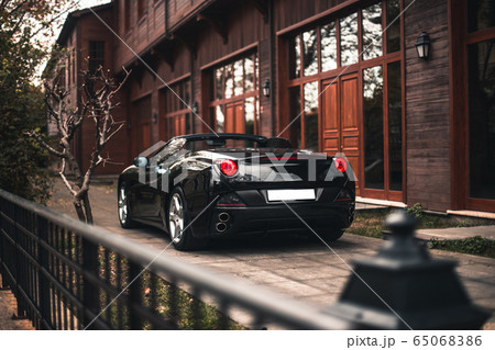 Black sedan car parked in front of a red apartment Black sedan car parked in front of a red apartment 65068386