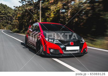 Black modern supercar with bordeaux roof in the forest,speed motion Black modern supercar with bordeaux roof in the forest,speed motion 65069126