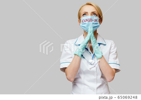 medical doctor nurse woman wearing protective mask and latex gloves - praying nad hoping gesture medical doctor nurse woman wearing protective mask and latex gloves - praying nad hoping gesture 65069248