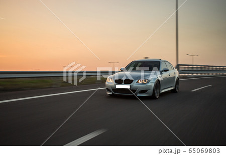 Silver sedan car in a long journey in the sunset Silver sedan car in a long journey in the sunset 65069803