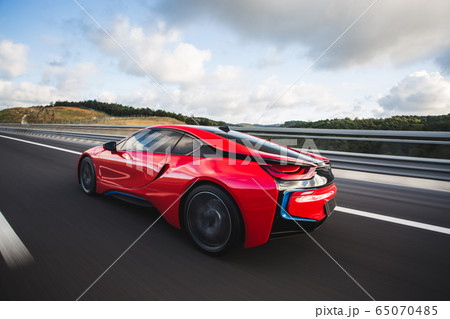 Red sport car with black autotuning speed drive on the autobahn Red sport car with black autotuning speed drive on the autobahn 65070485