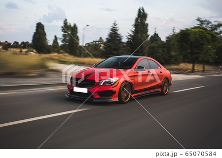 red sport sedan driving in the nature red sport sedan driving in the nature 65070584