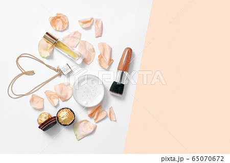 Perfume bottles with flowers petals on light 65070672