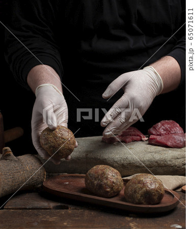 Cook makes cutlet with dark background 65071611