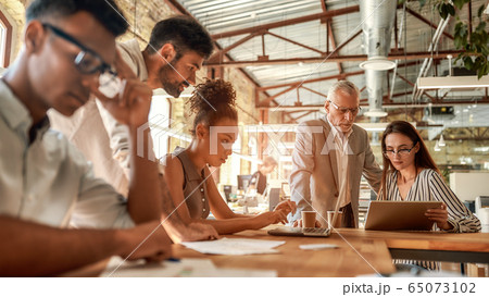 Busy day. Group of business people working together and communicating in the modern office 65073102