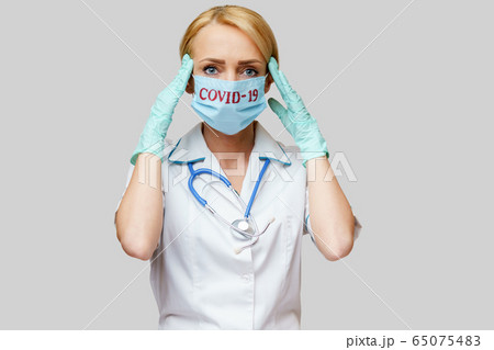 medical doctor nurse woman wearing protective mask and rubber or latex gloves - headache and stress 65075483
