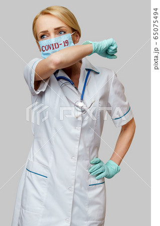 medical doctor nurse woman wearing protective mask and rubber or latex gloves - cough 65075494