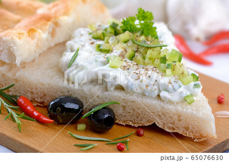 Fresh Greek tzatziki with garlic and cucumber on pita bread served with black olives and herbs Fresh Greek tzatziki with garlic and cucumber on pita bread served with black olives and herbs 65076630