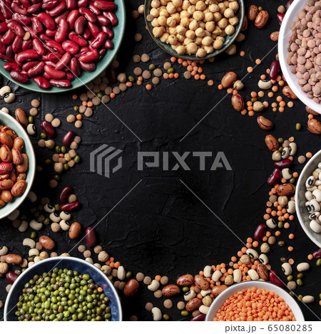 Legumes assortment, shot from above on a dark background with copy space. Lentils, soybeans, chickpeas, red kidney beans, a vatiety of pulses, forming a frame, a square design template Legumes assortment, shot from above on a dark background with copy space. Lentils, soybeans, chickpeas, red kidney beans, a vatiety of pulses, forming a frame, a square design template 65080285