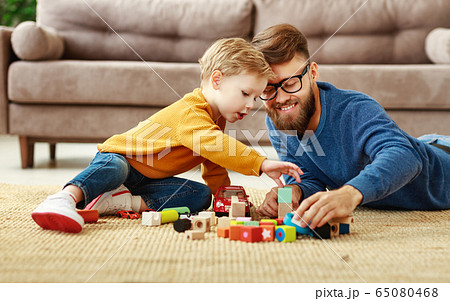 Happy dad and kid playing with toys at home. 65080468