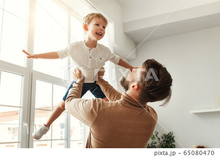 Happy man with little son having fun at home. Happy man with little son having fun at home. 65080470