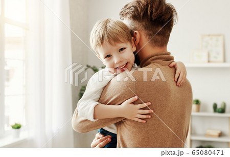 Father and child hugging at home. Father and child hugging at home. 65080471