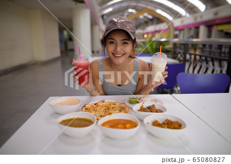 Young beautiful woman enjoying Indian food at restaurant Young beautiful woman enjoying Indian food at restaurant 65080827