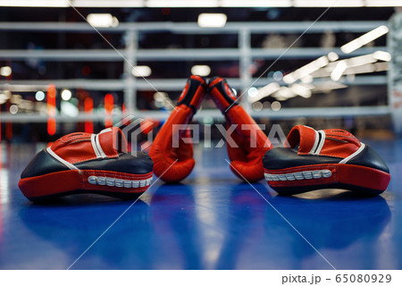 Pair of red boxing gloves and pads on ring, nobody 65080929