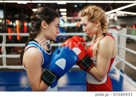 Women in red and blue gloves boxing on the ring 65080935