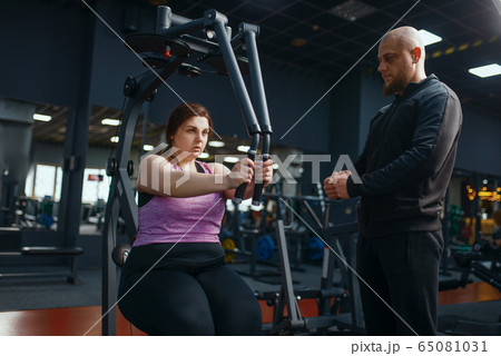 Overweight woman doing exercise in gym 65081031