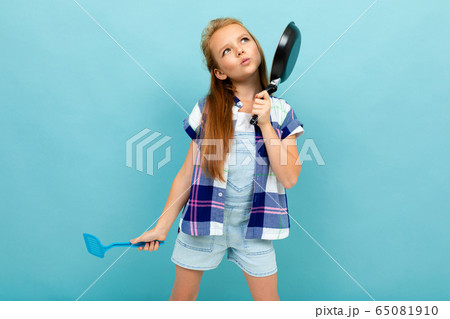 Teenager caucasian girl is going to fry something with a pan isolated on blue background 65081910