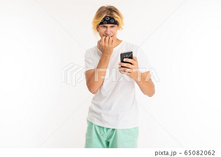 Beautiful young man with mobile phone isolated on white background Beautiful young man with mobile phone isolated on white background 65082062
