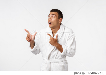 African american guy wearing a bathrobe pointing finger with surprise and happy emotion. Isolated over whtie background. African american guy wearing a bathrobe pointing finger with surprise and happy emotion. Isolated over whtie background. 65082240
