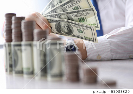 Man holds in his hand fan dollars, investment 65083329