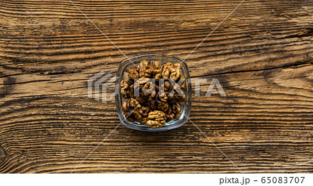 Walnut in a small plate on a vintage wooden table as a background. Walnuts is a healthy vegetarian protein nutritious food. Natural nuts snacks. Walnut in a small plate on a vintage wooden table as a background. Walnuts is a healthy vegetarian protein nutritious food. Natural nuts snacks. 65083707