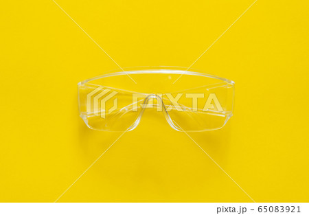 Protective glasses lying on a yellow background. Protective glasses lying on a yellow background. 65083921