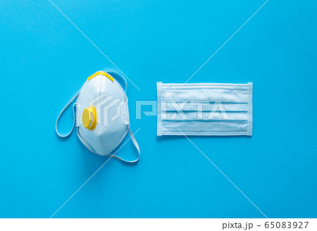 Medical protective mask and respirator ffp lie on a blue background. Anti-virus protection kit against covid-19. Coronavirus pandemic 2019. Medical protective mask and respirator ffp lie on a blue background. Anti-virus protection kit against covid-19. Coronavirus pandemic 2019. 65083927