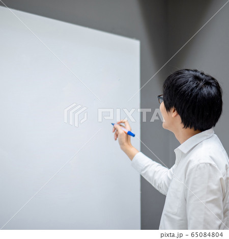 Asian man teacher writing on blank whiteboard 65084804