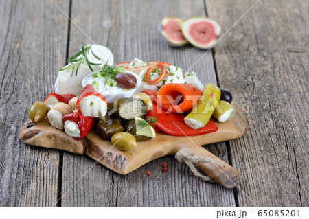A selection of typical Greek appetizers on a wooden cutting board A selection of typical Greek appetizers on a wooden cutting board 65085201