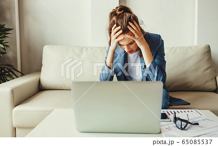 Frustrated busy woman sitting at table with laptop 65085537