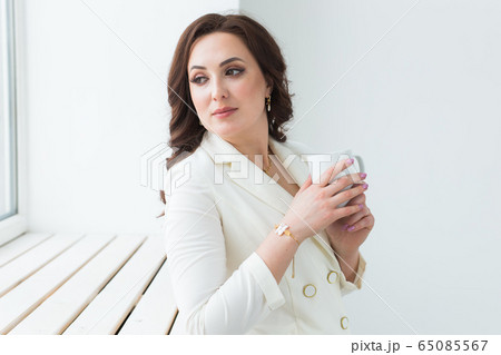 Woman holding a white cup of coffee. With a beautiful manicure. Drink, fashion, morning 65085567