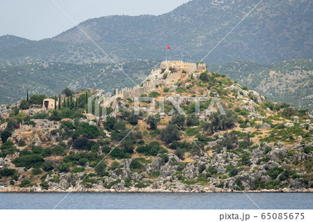 Kalekoy village with stone built houses and castle on top of hill in Uchagiz bay in Turkey near sunken city of Kekova 65085675